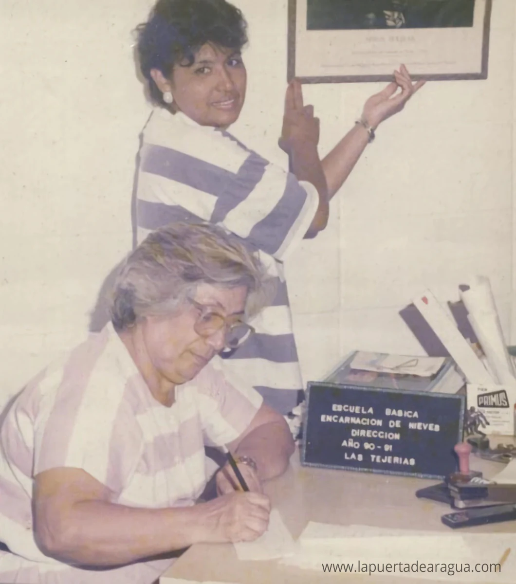 Aurora Delgado en la dirección de la Escuela Encarnación de Nieves durante el año escolar 1990-1991; al fondo, la docente Nancy Rodríguez.